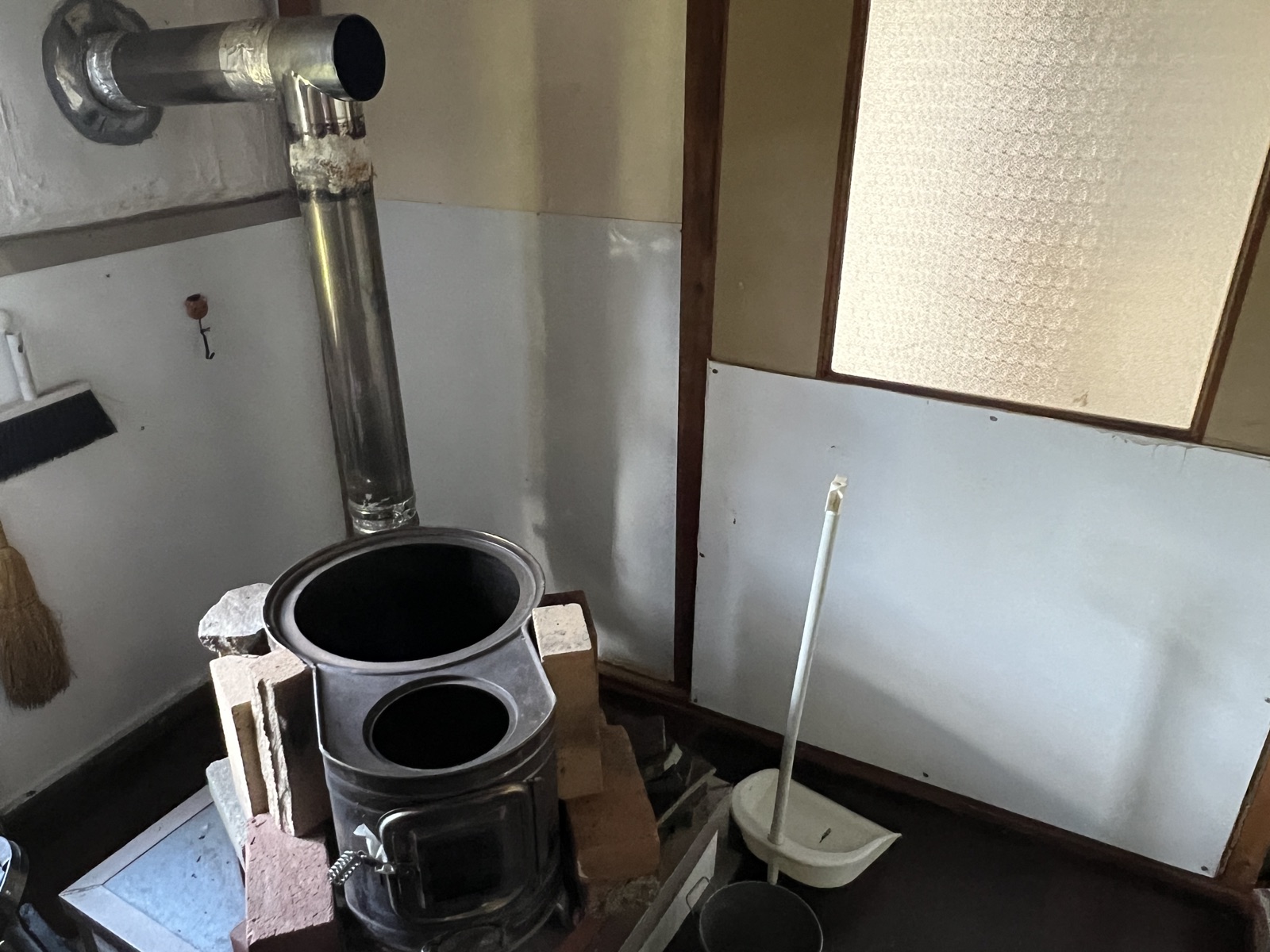 The cleaned wood stove, with its chimney pipe and open lid.
