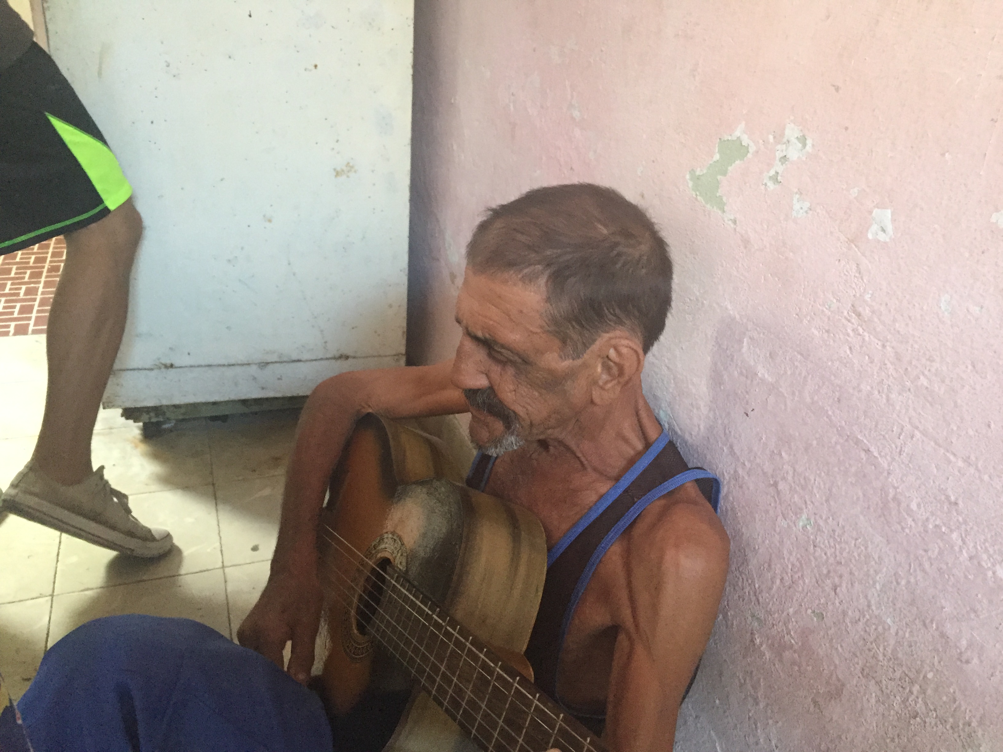 Papi tocando la guitarra sentado en el suelo — una escena cotidiana, 2016.